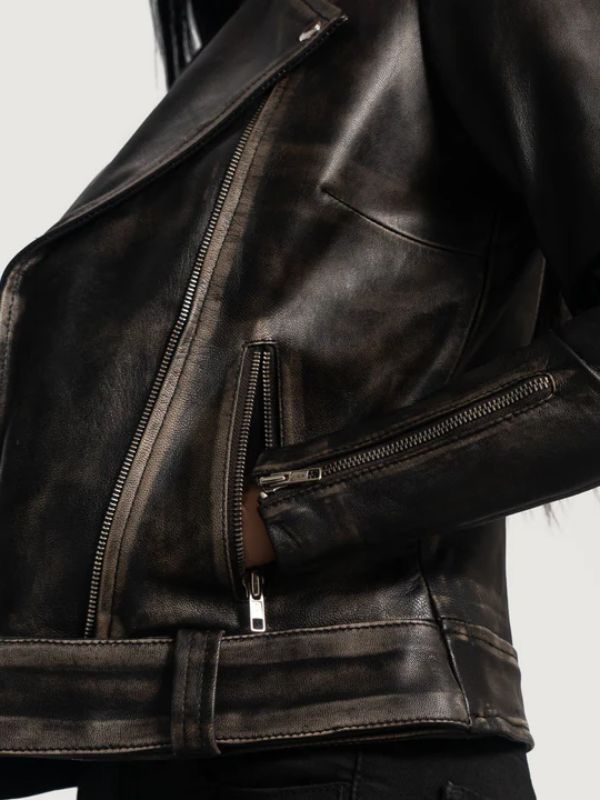 Close-up of a dark leather jacket with zippers on a light gray background