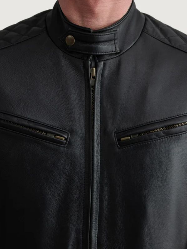 Close-up of a black leather jacket with zippers on a neutral background