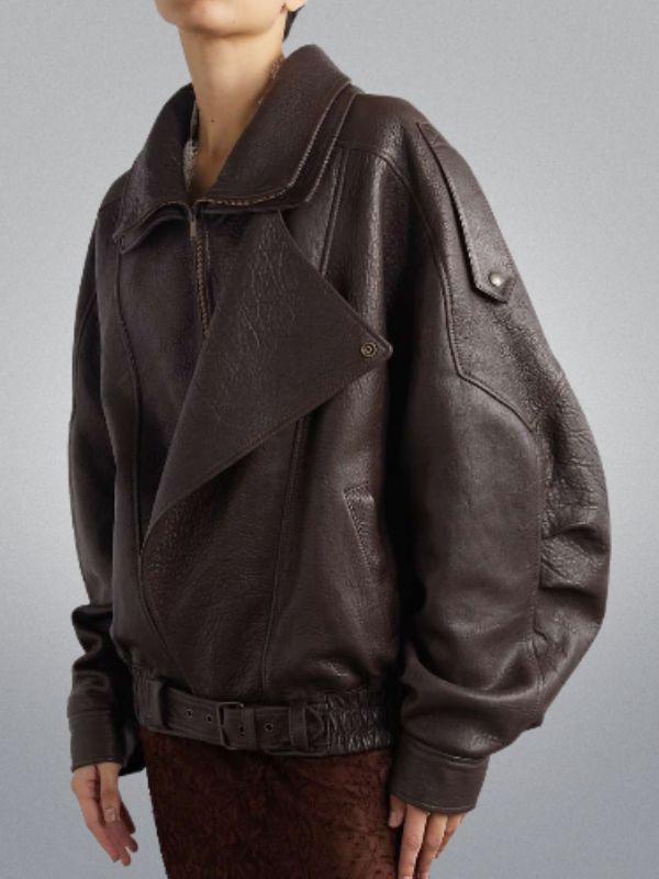 Brown leather jacket worn by a person on a gray background