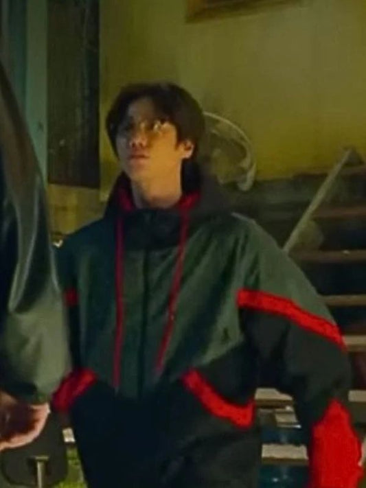 Person wearing a green and red jacket in an indoor setting