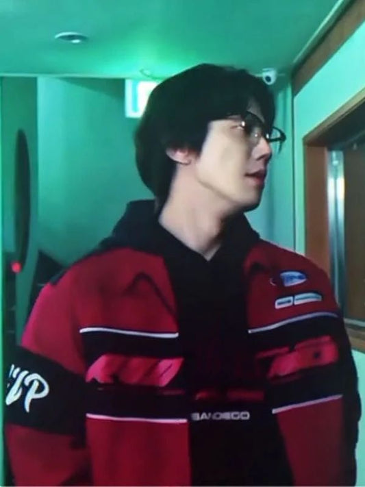 Person wearing a red and black jacket with visible branding in an indoor setting