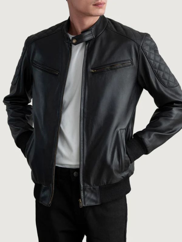 Person wearing a black leather jacket with quilted arm design on a light gray background